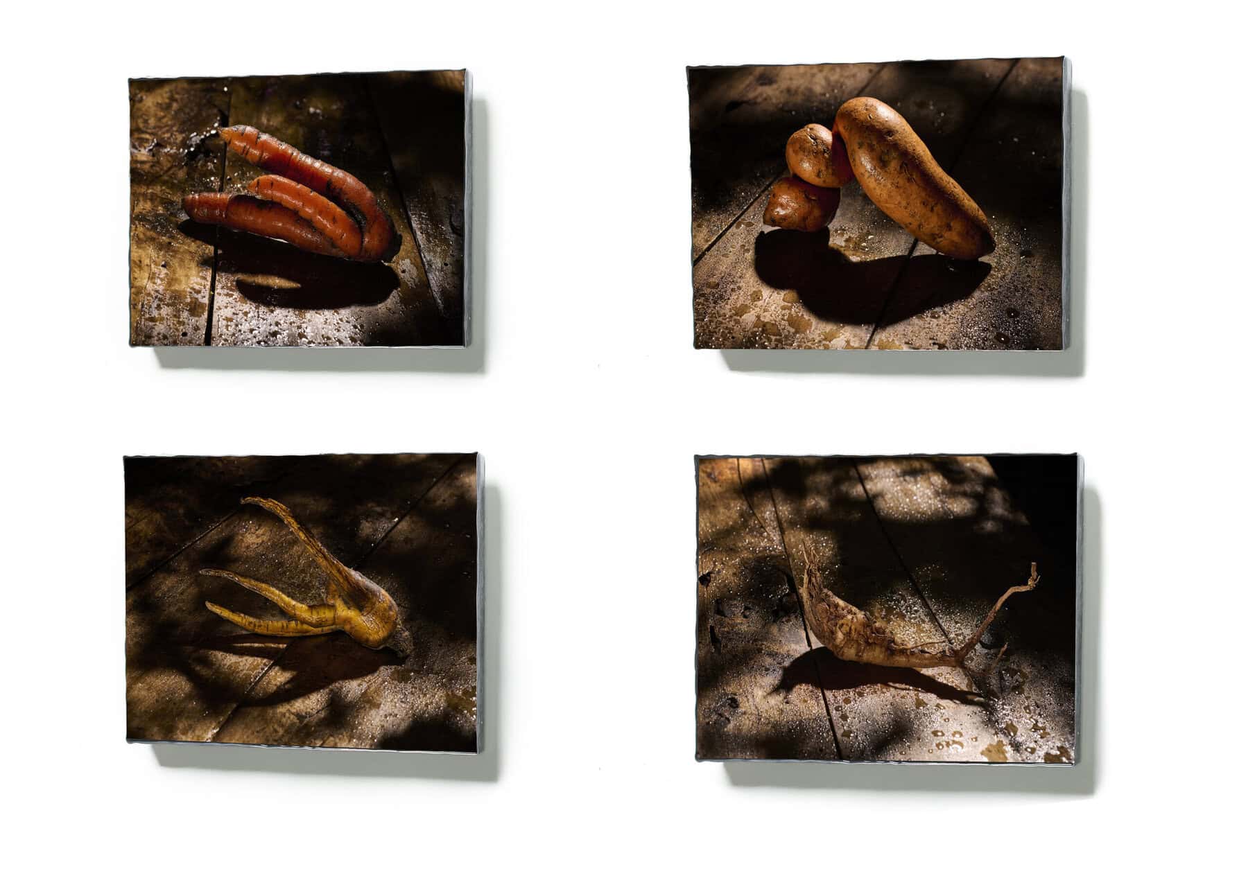 Vreemd gevormde wortelgroenten met schaduw op houten tafel.